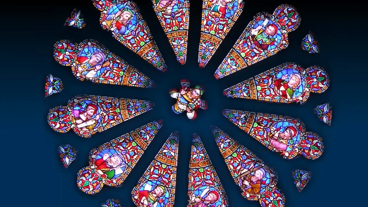 Close-up of a stained glass rose window with detailed tracery and saintly figures